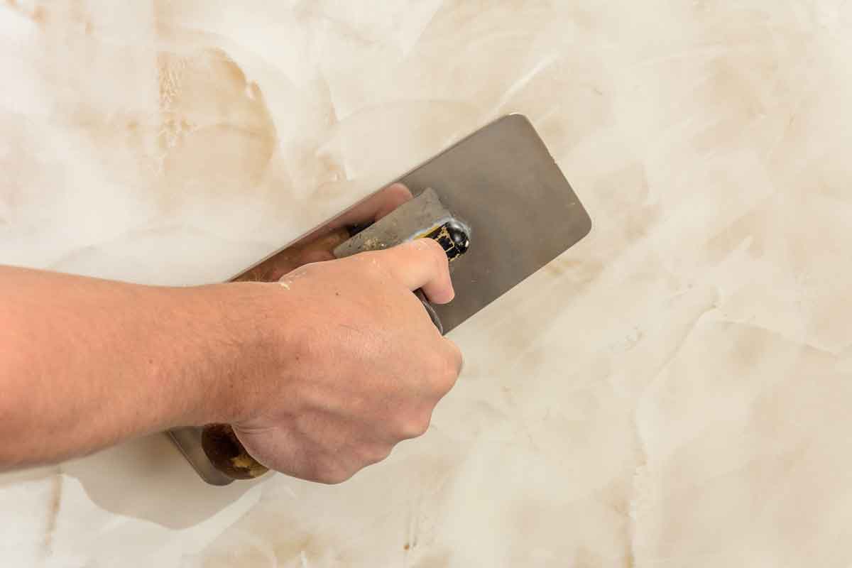 Remodeling contractor applying Venetian plaster to wall