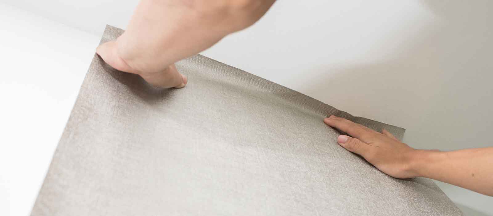 Home renovation contractor putting up wallpaper